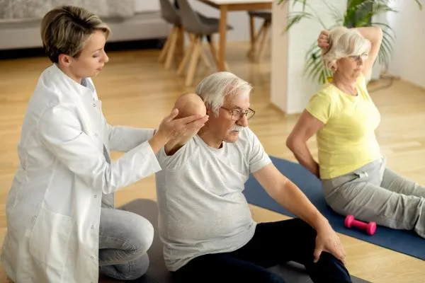 Therapist helping a patient with recovery exercises at home
